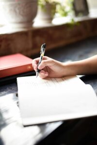 A woman writing her healthy habits to 
a healthy relationship in her journal.